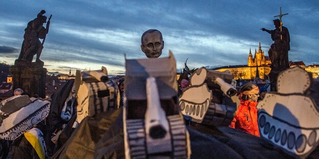 Menschen in Prag demonstrieren mit gebasteltem Putin-Kopf auf Panzern aus Pappe Menschen in Prag demonstrieren mit gebasteltem Putin-Kopf auf Panzern aus Pappe