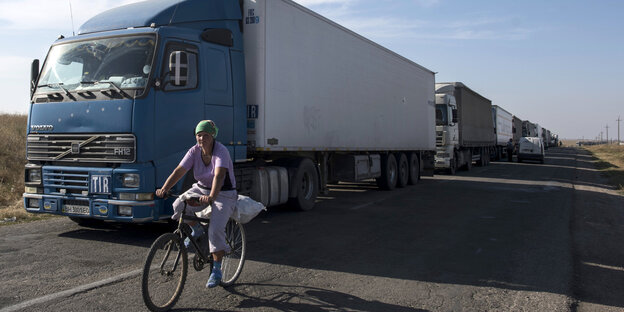 Frau auf Fahrrad fährt neben Lkw