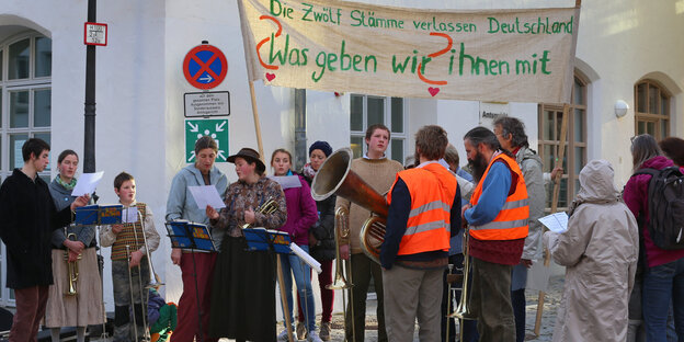 Menschen stehen mit einem Plakat auf einer Straße. Menschen stehen mit einem Plakat auf einer Straße.