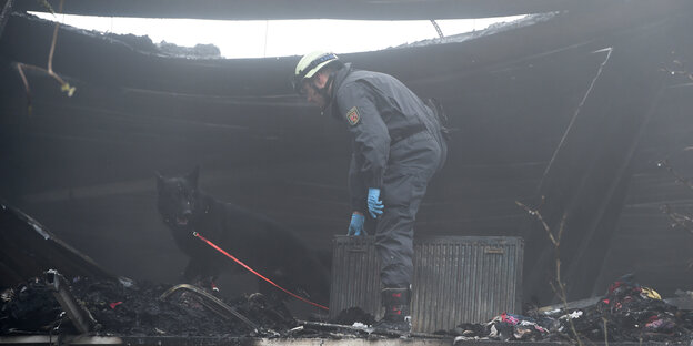 Ein Feuerwehrmann in dem ausgebrannten Gebäude. Ein Feuerwehrmann in dem ausgebrannten Gebäude.