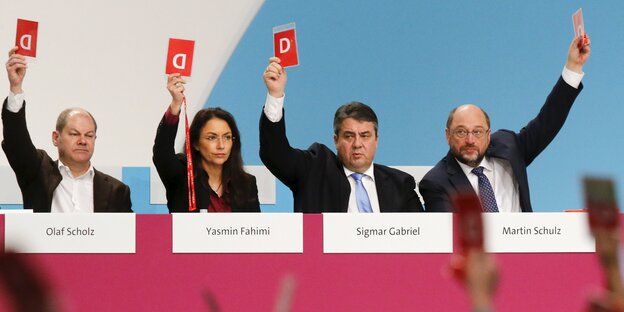 Menschen heben Zettel mit einem „D“ drauf. Menschen heben Zettel mit einem „D“ drauf.