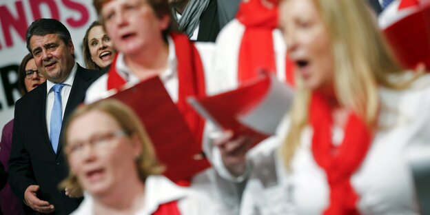 Sigmar Gabriel singt, neben ihm ein Chor mit roten Halstüchern Sigmar Gabriel singt, neben ihm ein Chor mit roten Halstüchern