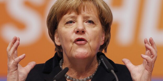 Angela Merkel im Porträt mit erhobenen Händen Angela Merkel im Porträt mit erhobenen Händen