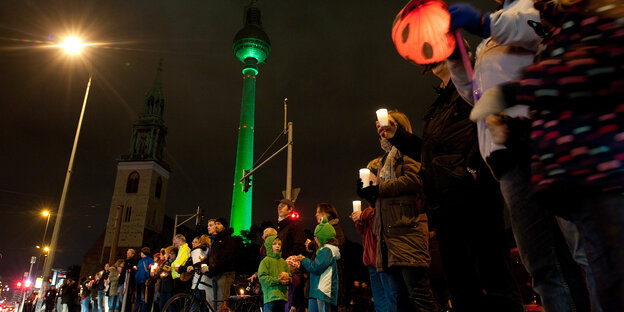Teilnehmer einer Lichterkette stehen am 17.10.2015 in Berlin am Alexanderplatz. Teilnehmer einer Lichterkette stehen am 17.10.2015 in Berlin am Alexanderplatz.