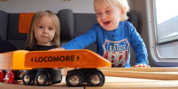 Kinder spielen mit einer Holzbahn Kinder spielen mit einer Holzbahn