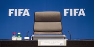Ein leerer Stuhl vor einer blauen Wand mit der Aufschrift "Fifa"