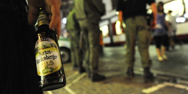 Ein Mann hält eine Bierflasche in der Hand. Ein Mann hält eine Bierflasche in der Hand.