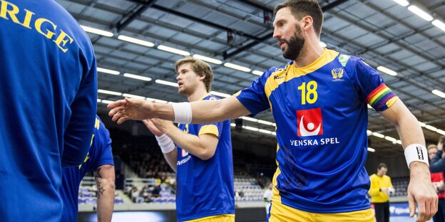 Der Handballer Tobias Karlsson auf dem Spielfeld mit Regenbogen-Kapitänsbinde Der Handballer Tobias Karlsson auf dem Spielfeld mit Regenbogen-Kapitänsbinde