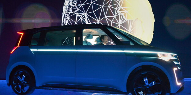 Ein Elektroauto, im Hintergrund ein Globus Ein Elektroauto, im Hintergrund ein Globus