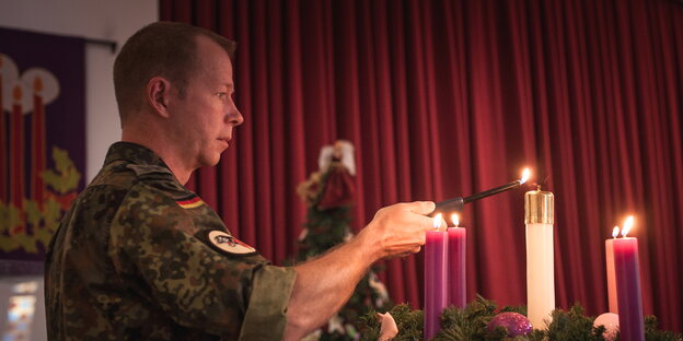 ein Soldat zündet Kerzen an ein Soldat zündet Kerzen an