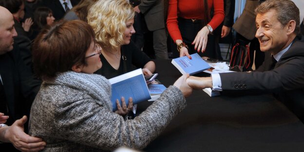 Nicolas Sarkozy schüttelt während seiner Buchsignierstunde Hände Nicolas Sarkozy schüttelt während seiner Buchsignierstunde Hände