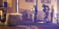 Zwei Feuerwehrmänner vor einem Haus.