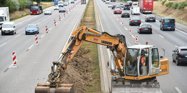 Bagger bearbeitet den Mittelstreifen einer Autobahn. Bagger bearbeitet den Mittelstreifen einer Autobahn.