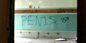 Penis steht an einer Wand